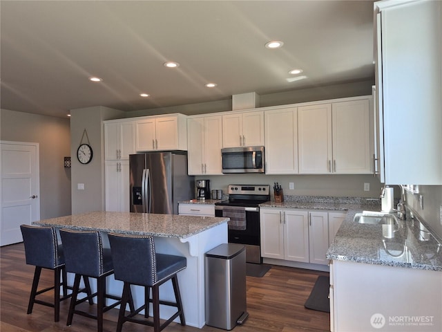 420 Hammond Ln, Rock Island, WA 98850 - kitchen featuring stainless steel appliances, white cabinets, a kitchen bar, dark wood finished floors, and recessed lighting