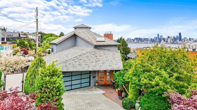 3406 SW Manning St, Seattle, WA 98126 - view of front of property featuring a shingled roof, a chimney, and decorative driveway