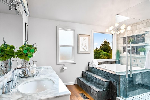 3406 SW Manning St, Seattle, WA 98126 - full bath with a bath, a shower stall, double vanity, wood finished floors, and a chandelier