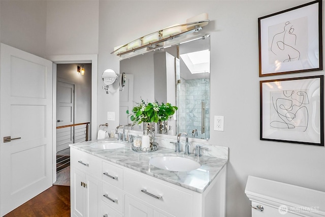 3406 SW Manning St, Seattle, WA 98126 - full bathroom with double vanity, a shower stall, wood finished floors, and a skylight