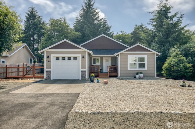 789 Island Cir SE, Ocean Shores, WA 98569 - view of front of house with covered porch, an attached garage, driveway, and stone siding