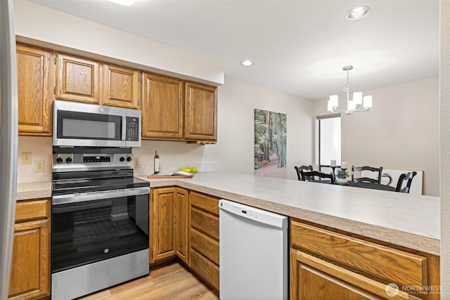 300 N Sequim Ave Unit 15, Sequim, WA 98382 - kitchen featuring stainless steel appliances, a chandelier, light wood finished floors, light countertops, and pendant lighting