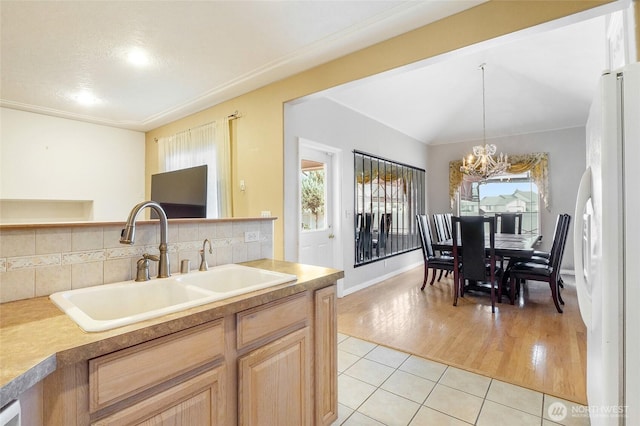 9460 Albert Way SE, Moses Lake, WA 98837 - kitchen with freestanding refrigerator, a chandelier, light tile patterned floors, light brown cabinets, and decorative backsplash