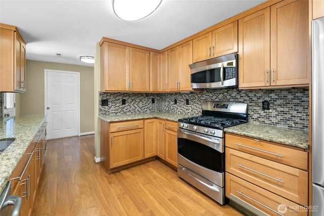 22526 87th Pl W, Edmonds, WA 98026 - kitchen with stainless steel appliances, light wood finished floors, tasteful backsplash, and light stone counters