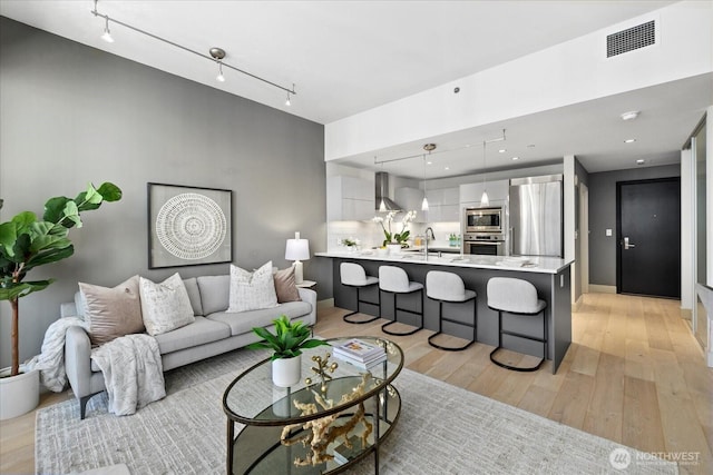 737 Olive Way Unit 1903, Seattle, WA 98101 - living area featuring light wood-style flooring and rail lighting