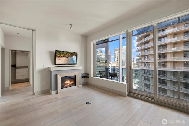 737 Olive Way Unit 1903, Seattle, WA 98101 - unfurnished living room featuring wood finished floors and a glass covered fireplace