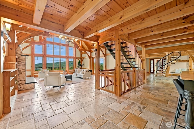 991 Lakeview St, Bellingham, WA 98229 - unfurnished living room with stone tile floors, stairway, arched walkways, a wooden ceiling with exposed beams, and a chandelier