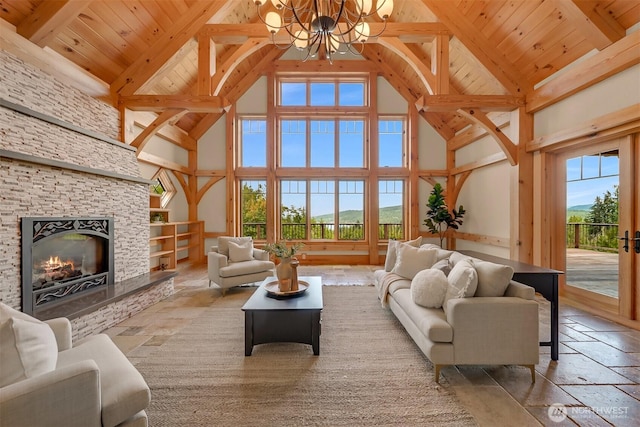 991 Lakeview St, Bellingham, WA 98229 - living area featuring high vaulted ceiling, a chandelier, a wooden ceiling with exposed beams, healthy amount of natural light, and a stone fireplace