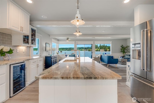 5341 S Bercot Rd, Freeland, WA 98249 - kitchen featuring high quality fridge, beverage cooler, light wood finished floors, white cabinetry, and recessed lighting