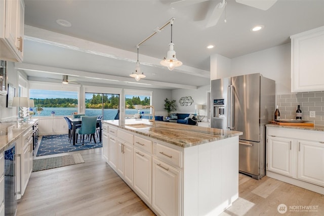 5341 S Bercot Rd, Freeland, WA 98249 - kitchen with high end refrigerator, a ceiling fan, light wood-style floors, white cabinetry, and light stone counters