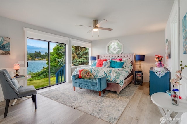 5341 S Bercot Rd, Freeland, WA 98249 - bedroom with wood finished floors, a wainscoted wall, a ceiling fan, a water view, and access to exterior