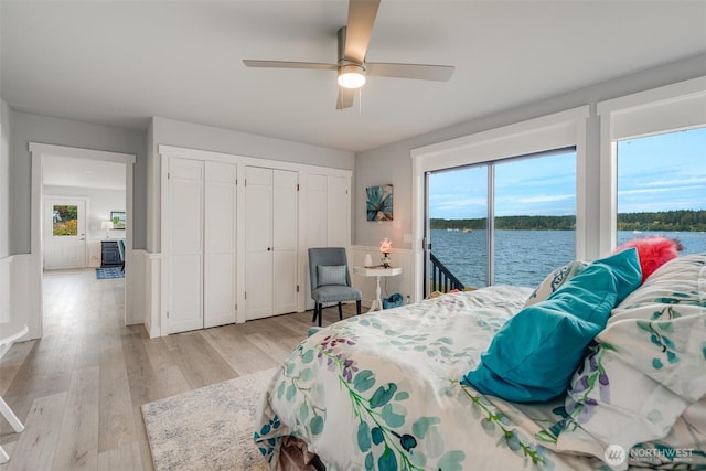 5341 S Bercot Rd, Freeland, WA 98249 - bedroom with access to outside, two closets, wainscoting, light wood-style floors, and a water view