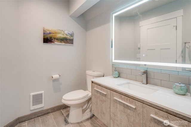 5341 S Bercot Rd, Freeland, WA 98249 - half bath featuring vanity, backsplash, heating unit, and wood finish floors