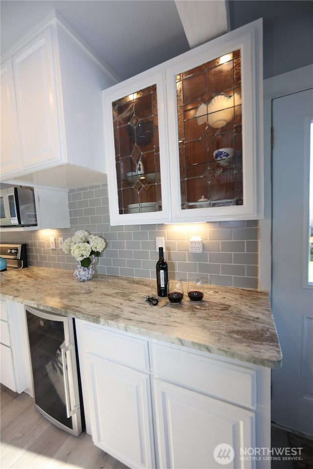5341 S Bercot Rd, Freeland, WA 98249 - indoor dry bar featuring stainless steel microwave, wine cooler, tasteful backsplash, and light wood finished floors