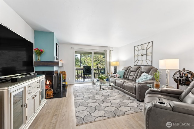 7501 Ruby Dr SW Unit G202, Lakewood, WA 98498 - living area featuring light wood-type flooring and a lit fireplace