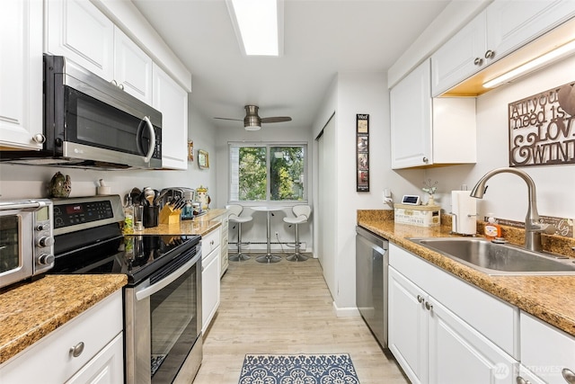7501 Ruby Dr SW Unit G202, Lakewood, WA 98498 - kitchen featuring appliances with stainless steel finishes, light wood-type flooring, and white cabinets