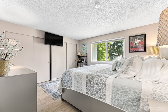 7501 Ruby Dr SW Unit G202, Lakewood, WA 98498 - bedroom with a textured ceiling and light wood finished floors
