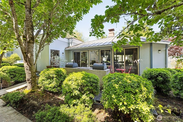 7501 Ruby Dr SW Unit G202, Lakewood, WA 98498 - back of house featuring a standing seam roof, a metal roof, a chimney, and a sunroom