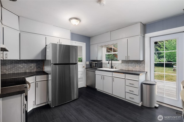 5140 Johnson Point Rd NE, Olympia, WA 98516 - kitchen with stainless steel appliances, dark countertops, decorative backsplash, and white cabinets