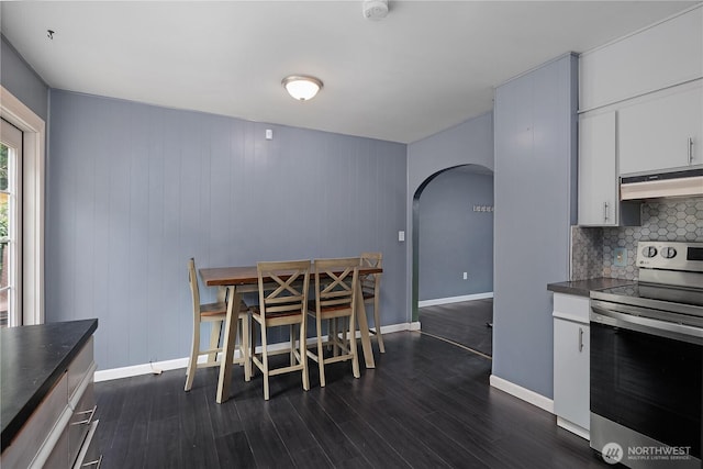 5140 Johnson Point Rd NE, Olympia, WA 98516 - dining room featuring arched walkways and dark wood-style floors