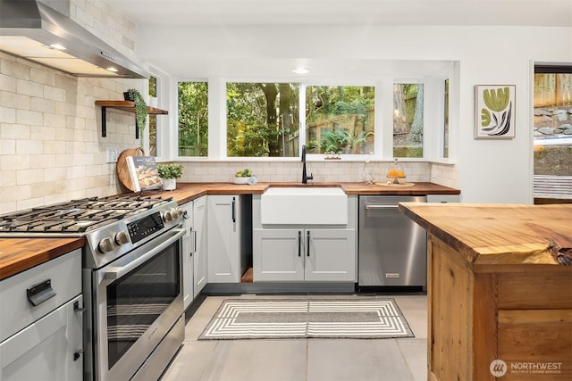 6687 NE Bayview Blvd, Bainbridge Island, WA 98110 - kitchen featuring wood counters, appliances with stainless steel finishes, ventilation hood, and open shelves