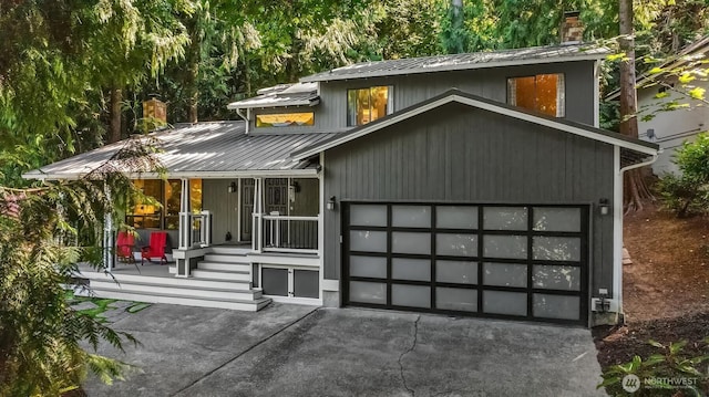 6687 NE Bayview Blvd, Bainbridge Island, WA 98110 - view of front of home with a chimney, a porch, driveway, a metal roof, and a standing seam roof