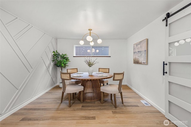 8808 NE 139th St, Kirkland, WA 98034 - dining area with built in shelves, a decorative wall, light wood-style flooring, a barn door, and a chandelier