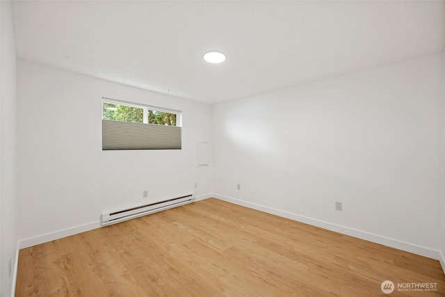 6604 S Madison St, Tacoma, WA 98409 - unfurnished room with a baseboard heating unit and light wood-style floors