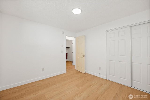 6604 S Madison St, Tacoma, WA 98409 - unfurnished bedroom with light wood-style flooring, a closet, and a textured ceiling