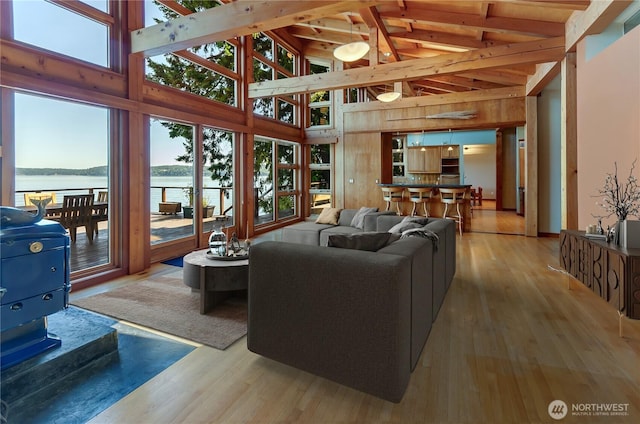 9913 Point View St NE, Olympia, WA 98516 - living room with high vaulted ceiling, light wood-style flooring, a water view, beam ceiling, and wooden walls
