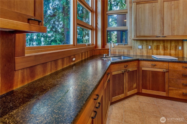 9913 Point View St NE, Olympia, WA 98516 - kitchen featuring light tile patterned floors, brown cabinetry, and dark stone countertops