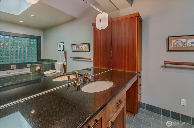 9913 Point View St NE, Olympia, WA 98516 - bathroom featuring tiled tub, vanity, a skylight, recessed lighting, and tile patterned floors