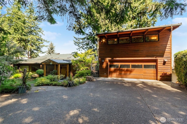 9913 Point View St NE, Olympia, WA 98516 - chalet / cabin with driveway, a garage, and stairway