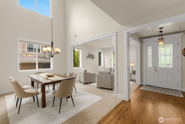 3414 SE 223rd Ave, Sammamish, WA 98075 - dining area with plenty of natural light, a chandelier, a towering ceiling, light wood-style flooring, and light colored carpet