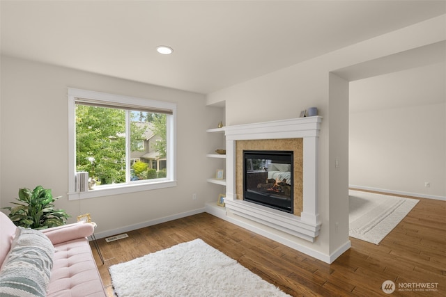 3414 SE 223rd Ave, Sammamish, WA 98075 - living room with wood finished floors, a tiled fireplace, recessed lighting, and built in features