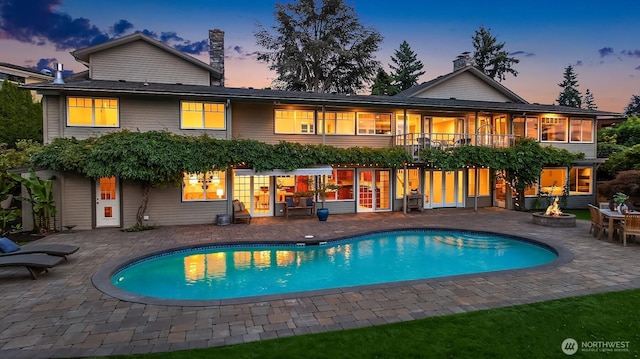 9620 NE 28th St, Clyde Hill, WA 98004 - back of property featuring a patio, a chimney, a fire pit, an outdoor pool, and a balcony