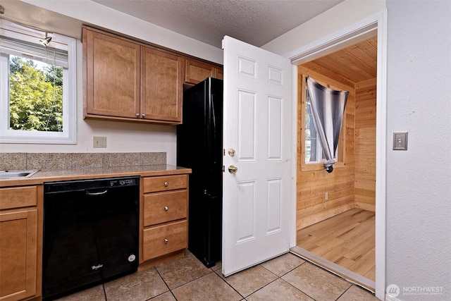 2059 Beverly Blvd, Shelton, WA 98584 - kitchen featuring dishwasher, wood walls, light tile patterned flooring, and brown cabinets