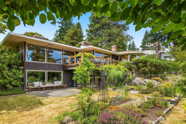 3912 NE 127th St, Seattle, WA 98125 - back of house with a patio area, a deck, outdoor lounge area, a vegetable garden, and a yard