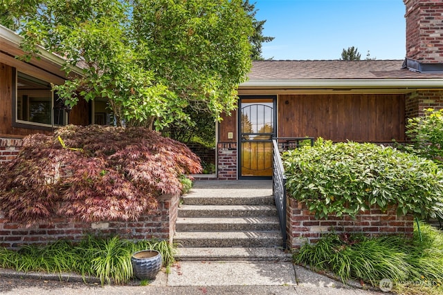 3912 NE 127th St, Seattle, WA 98125 - view of exterior entry featuring a chimney, brick siding, and a shingled roof