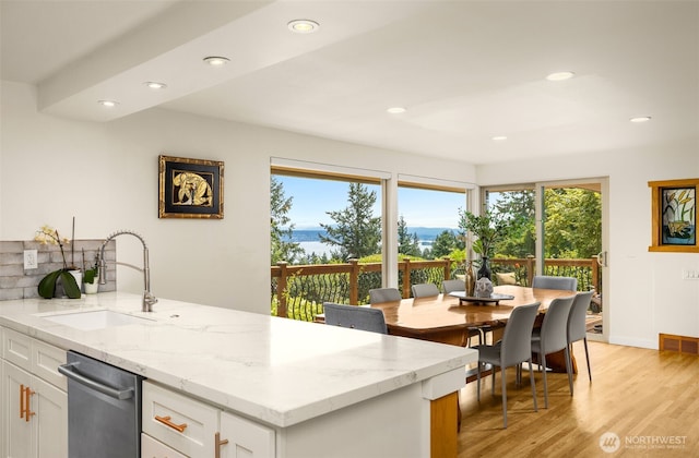 3912 NE 127th St, Seattle, WA 98125 - kitchen featuring stainless steel dishwasher, recessed lighting, light wood-style floors, light stone countertops, and white cabinets