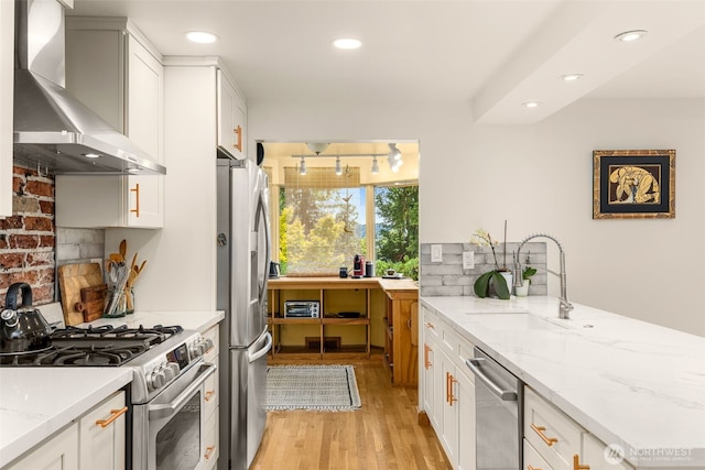 3912 NE 127th St, Seattle, WA 98125 - kitchen with wall chimney range hood, stainless steel appliances, light wood finished floors, white cabinetry, and recessed lighting