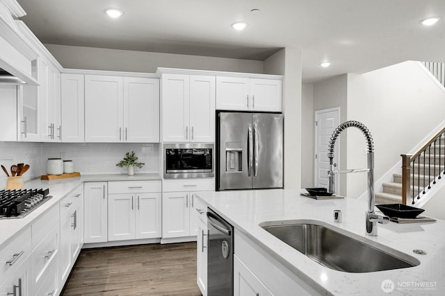 3941 233rd St SE, Bothell, WA 98021 - kitchen with appliances with stainless steel finishes, white cabinetry, recessed lighting, backsplash, and light stone countertops