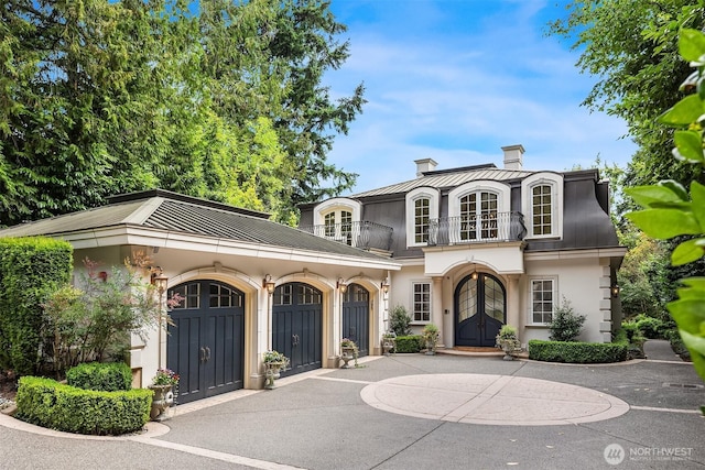 3210 Hunts Point Rd, Hunts Point, WA 98004 - view of front of house with a balcony, french doors, stucco siding, a chimney, and driveway