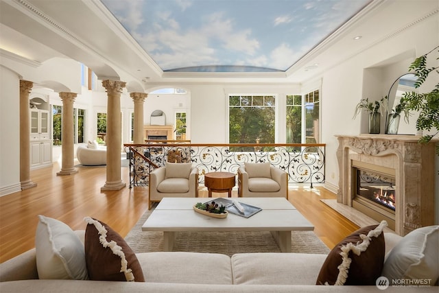 3210 Hunts Point Rd, Hunts Point, WA 98004 - living area with a premium fireplace, ornate columns, a tray ceiling, and plenty of natural light