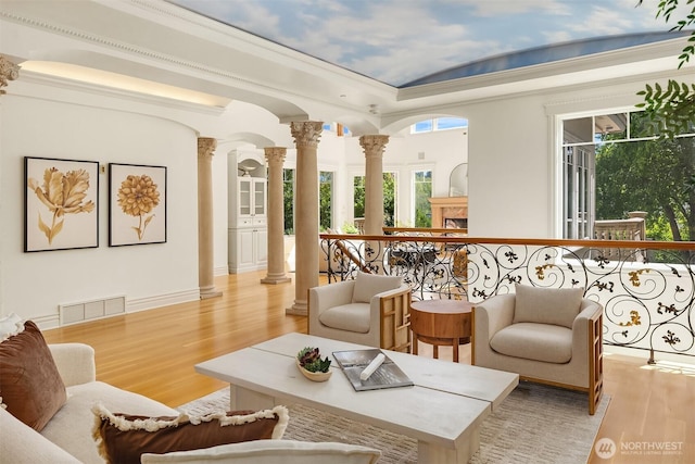 3210 Hunts Point Rd, Hunts Point, WA 98004 - living area with ornate columns, light wood-style flooring, and a tray ceiling