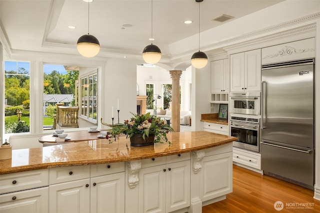 3210 Hunts Point Rd, Hunts Point, WA 98004 - kitchen with stainless steel appliances, ornate columns, a tray ceiling, light stone countertops, and recessed lighting
