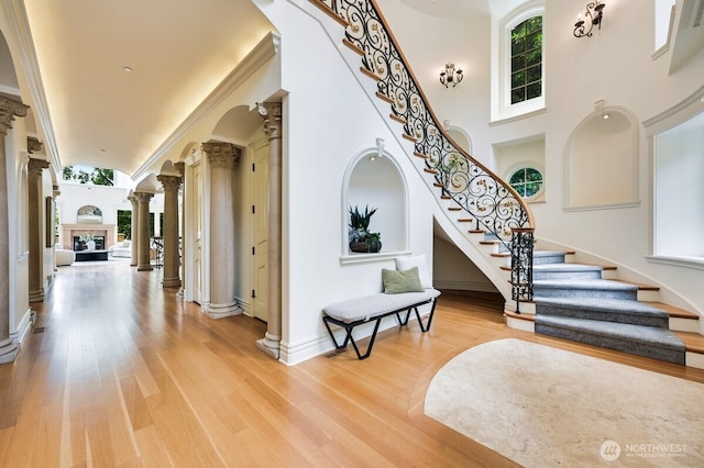 3210 Hunts Point Rd, Hunts Point, WA 98004 - foyer featuring decorative columns, stairs, light wood finished floors, and a towering ceiling