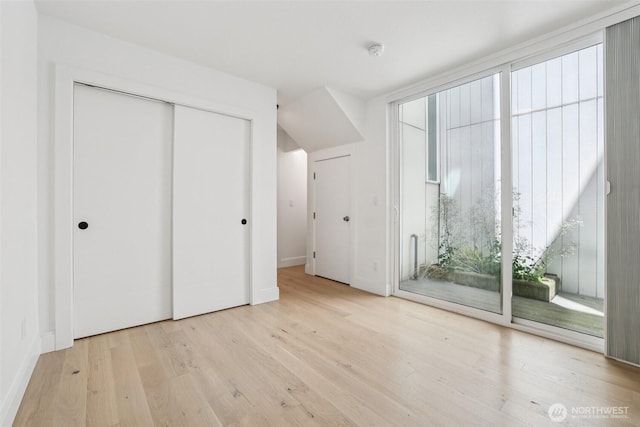805 Taylor Ave N Unit D, Seattle, WA 98109 - unfurnished bedroom with wood finished floors, access to exterior, and a closet