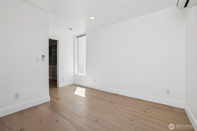 805 Taylor Ave N Unit D, Seattle, WA 98109 - spare room with a wall unit AC, wood finished floors, and recessed lighting