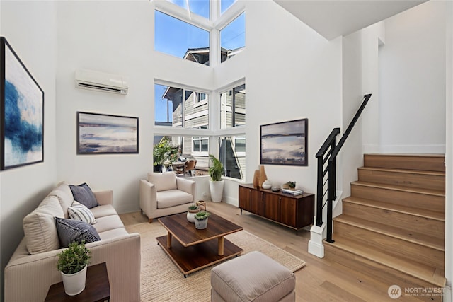 805 Taylor Ave N Unit D, Seattle, WA 98109 - living area with a wall unit AC, light wood-type flooring, a high ceiling, and stairs